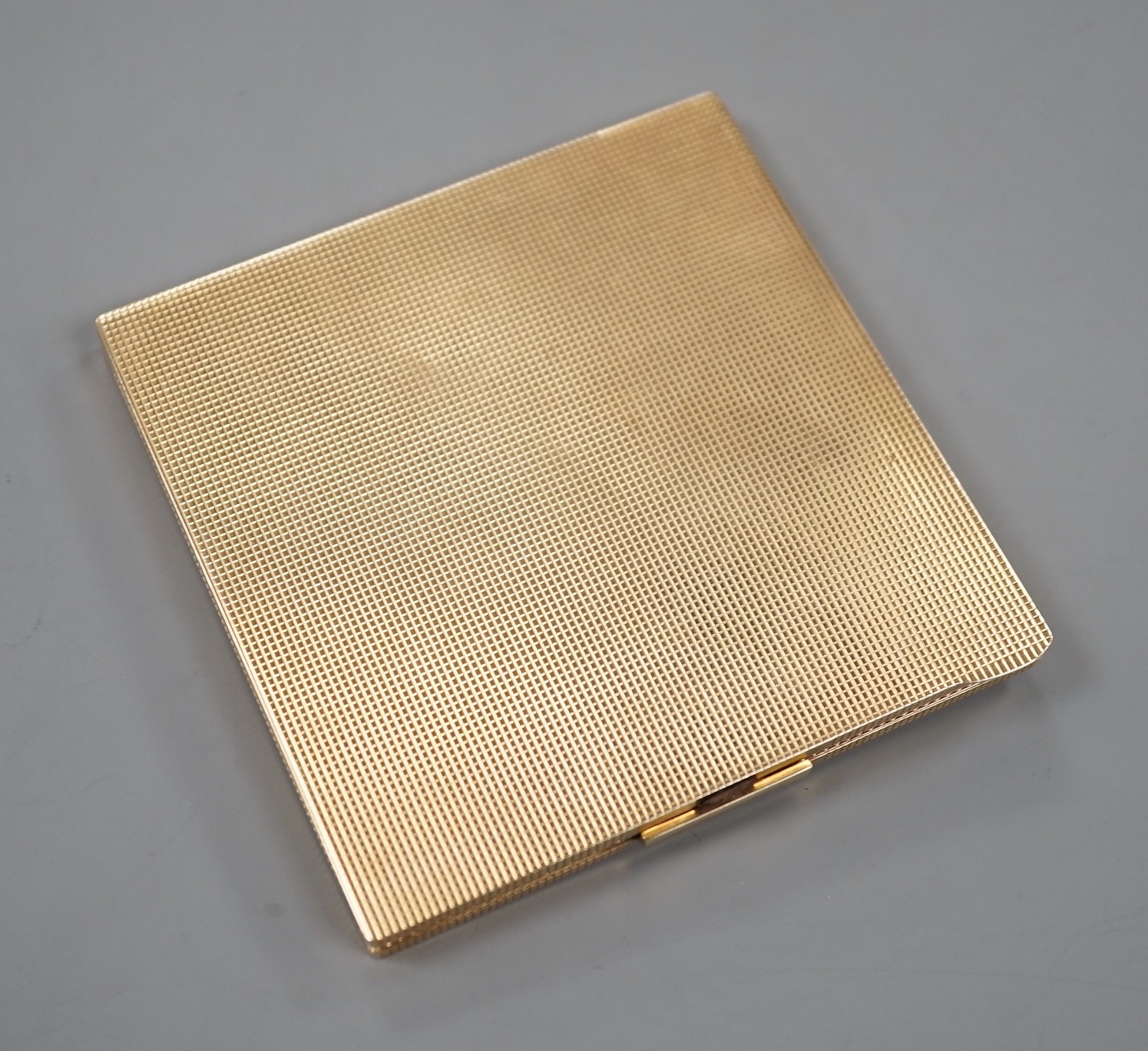 A 1940's engine turned 9ct gold compact, 82mm, gross 117.8 grams.